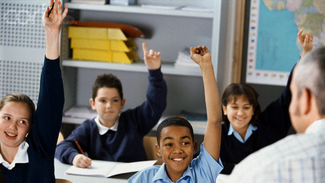 View of students raising their hands in a class setting --- Image by © Corbis